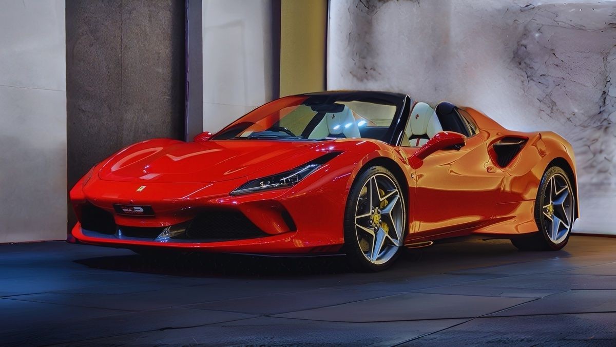 A sleek, red convertible sports car parked indoors with a modern, minimalist background.