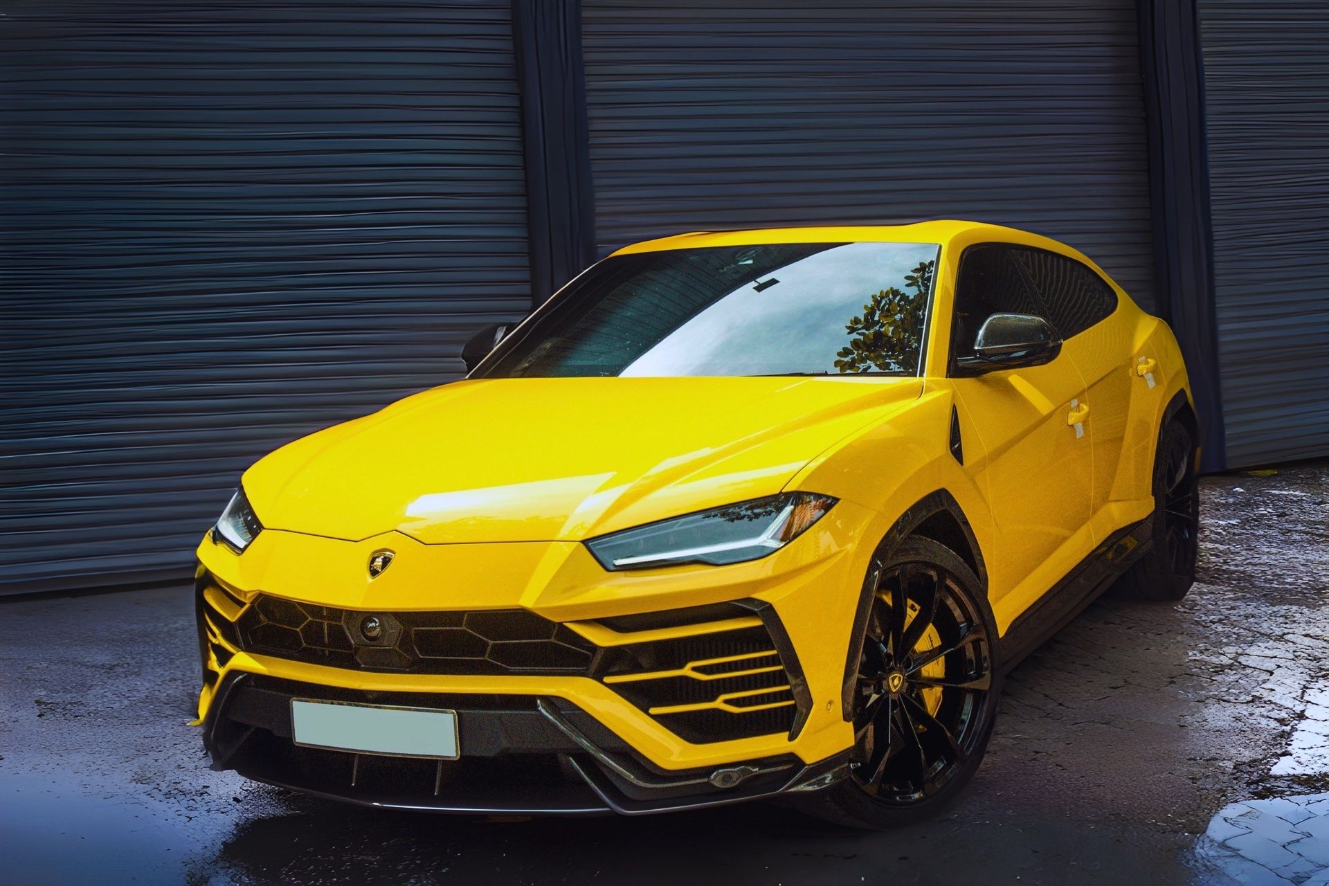 Yellow luxury SUV parked in front of a closed industrial garage door.